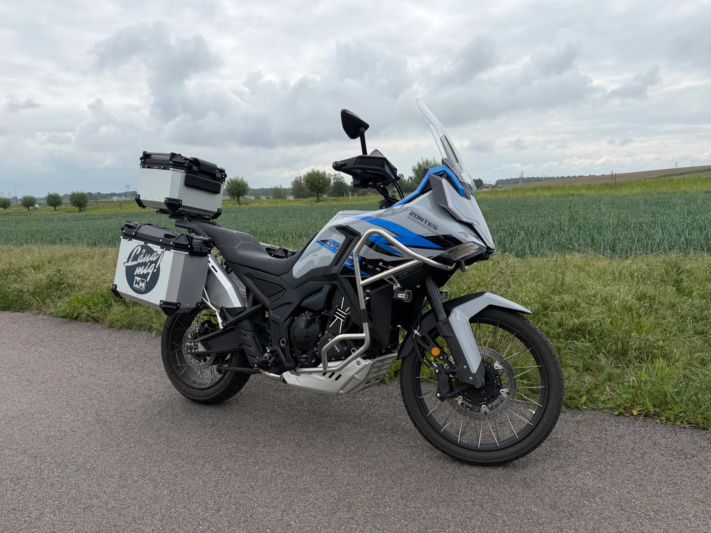 Zontes adventure-motorcykel med MotorMedlarna-väskor på en landsväg i Skåne